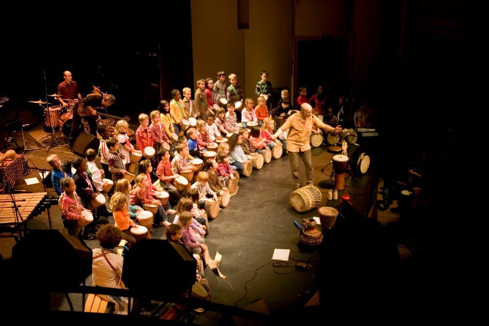 Des enfants sur scène avec Pascal Bihannic et les musiciens du sectacle Les Tambours d'Akatu